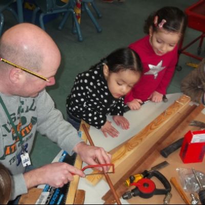 Darren Gregory (our caretaker) showing children how to cut wood safely